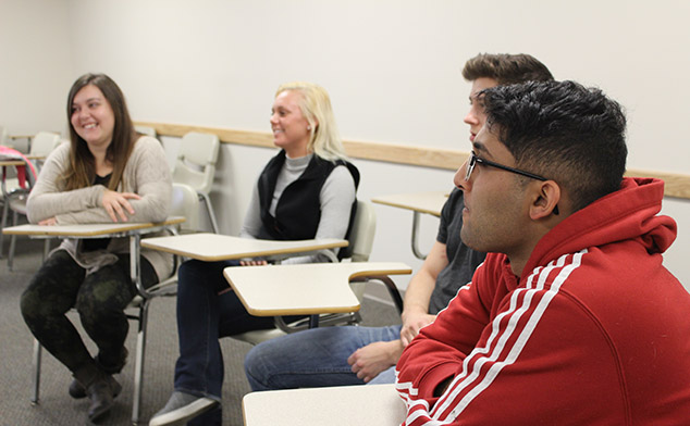 A group of students intently listening in a class discussion session.
