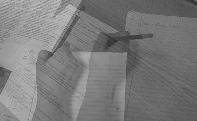 Photo of a hand writing on papers.