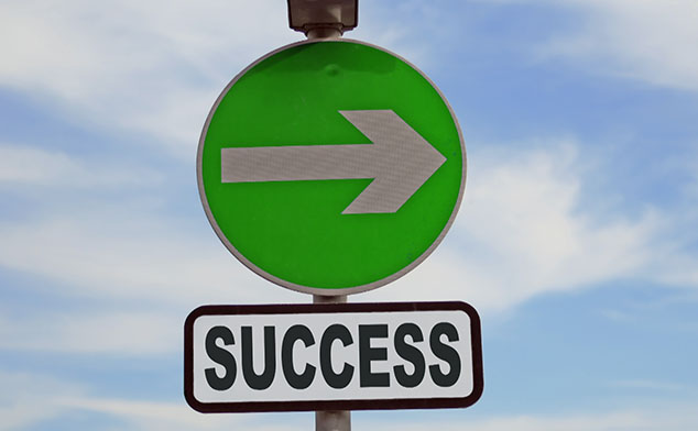 Photo of a sign with an arrow that says Success on it.